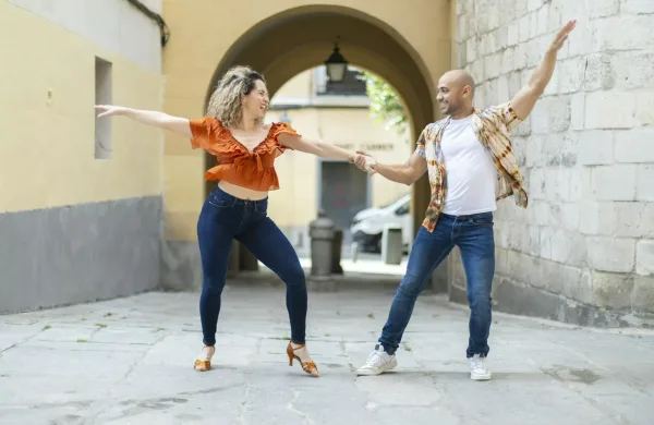 Cuban dancers perform a lively Latin dance in a sunny urban alley, full of energy and joy. Cuban dancers perform a lively Latin dance in a sunny urban alley, full of energy and joy.