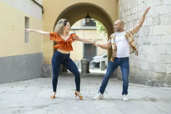 Cuban dancers perform a lively Latin dance in a sunny urban alley, full of energy and joy. Cuban dancers perform a lively Latin dance in a sunny urban alley, full of energy and joy.